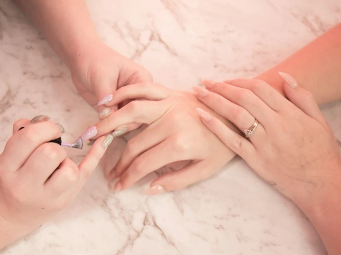 person holding silver ring on white textile Organic Beauty Salon