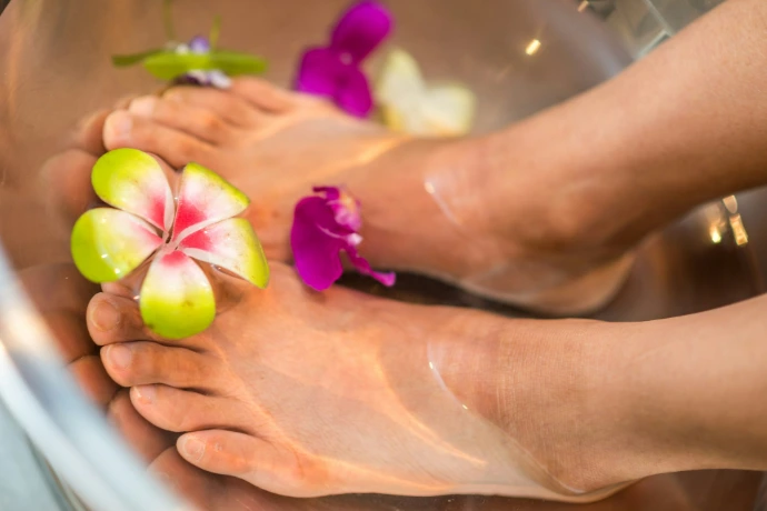 person's feet with flowers Organic Beauty Salon